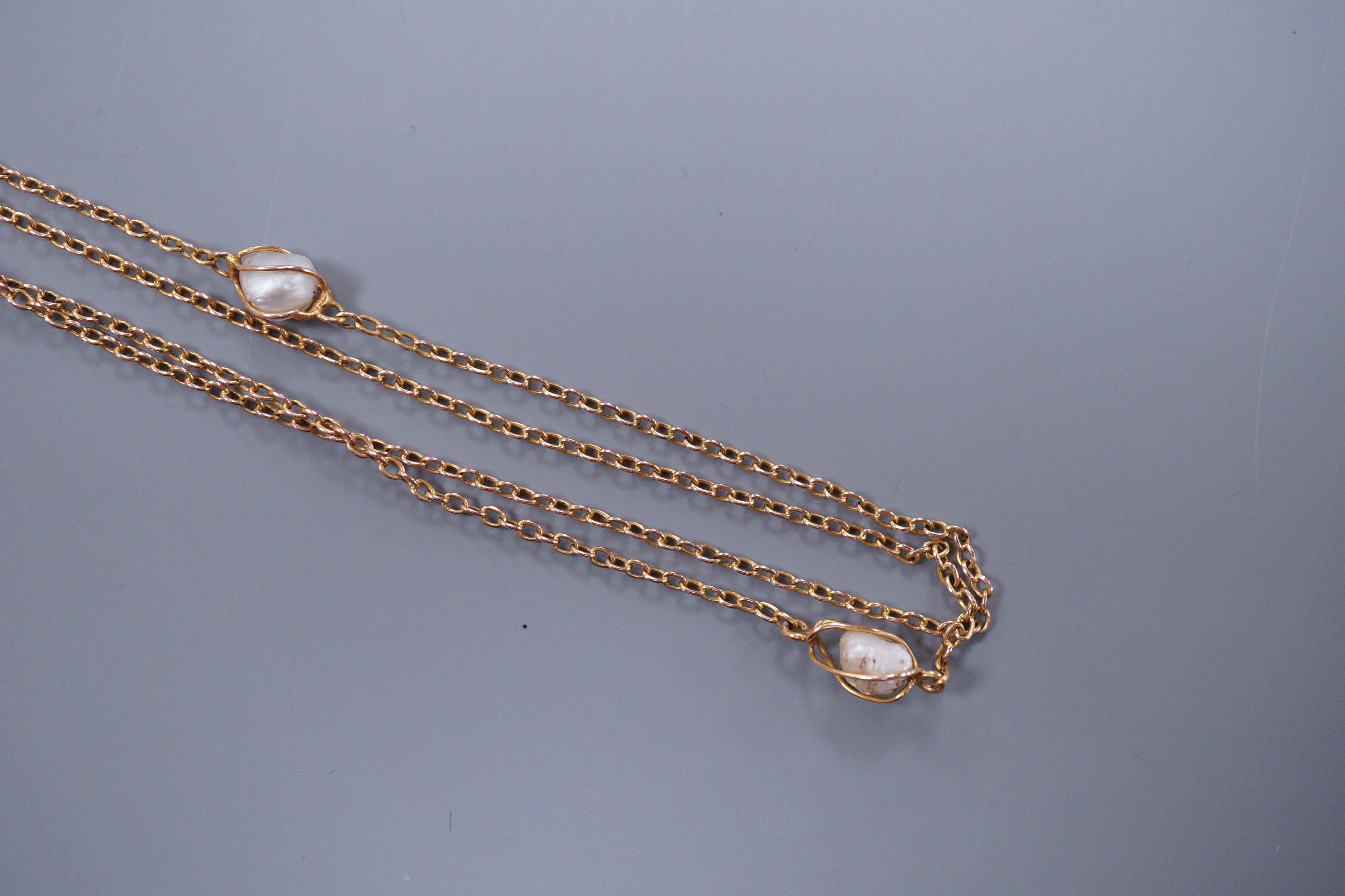 An early 20th century unmarked gold and baroque pearl chain necklace, 137cm
